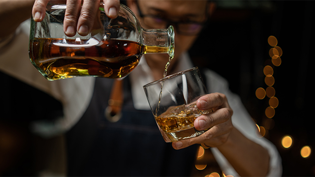 man pouring whiskey